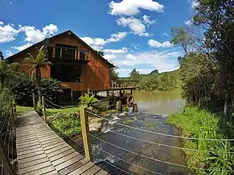 Hotel LinderHof com o Rio dos Cedros (rio) e a ponte de entrada pro hotel.