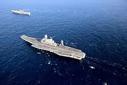 INS Vikramaditya (R33) e o INS Viraat (R22) no Mar Arábico em 2014. Um Sea Harrier do Viraat sobrevoa os navios.