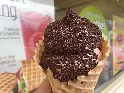 Sorvete cremoso de chocolate com confeitos em casquinha de waffle