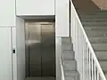 Um dos elevadores e escadas no interior
