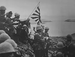 Tropas japonesas hasteiam a bandeira de batalha imperial na ilha de Kiska, no arquipélago das Aleutas, em 6 de junho de 1942.
