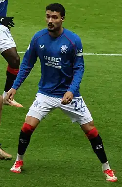 Um jogador se movimentando em campo, com uma feição de concentrado.