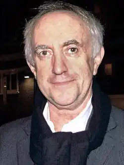 Jonathan Pryce olhando para a câmera.