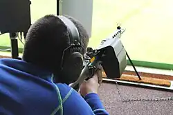 Um atirador júnior na Suíça exercitando tiro ao alvo com uma SIG SG 550. O rifle está equipado com um apanhador de cartuchos para evitar perturbar outros atiradores com a ejeção.