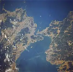 O Estreito Kanmon visto do espaço, com Kitakyushu a esquerda e Shimonoseki a direita. O novo aeroporto também é visível.