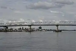 Ponte Kapuas sobre o Rio Kapuas, com céu azul e vegetação nas margens do rio ao redor.