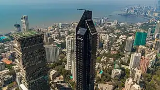 Mansão Antilia, seu heliponto e Lodha Altamount, com a fachada preta com uma coroa no topo a torna única e distinta, além do horizonte de Bombaim