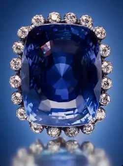 Large blue sapphire surrounded by twenty diamonds