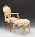 Fauteuil estilo Luís XVI dourado, com pérolas falsas e otomana.