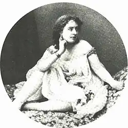 Young woman with dark hair and moderately revealing pseudo-Ancient-Greek costume