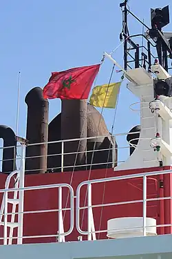 Bandeira de cortesia do estado visitado (bandeira nacional de Marrocos) e sinal de pedido de livre prática (bandeira Q do CIS) içados no cargueiro singapurense Monte Alegre