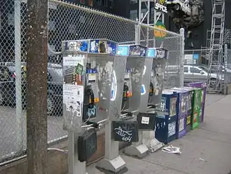 Telefones públicos em Toronto cobertos de pichações e avisos.
