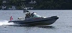 Barco da polícia norueguesa navegando pelo Drøbak Sound no fiorde de Oslo, em uma missão de resgate à fortaleza de Oscarsborg.
