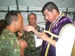 O Capitão Capelão João Batista entrega a comunhão para militares no Haiti.