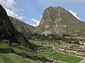 A montanha Pinkuylluna (à direita) acima da cidade Ollantaytambo. Uma enorme face de pedra é visível ao lado das ruínas de Pinkuylluna.