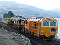Plasser and Theurer DGS 62 N dynamic track stabilizer, seguido de uma reguladora SSP 300 Regulator, e uma Plasser 09-16 CAT Continuous Action Tamper, in Blueskin Bay, Nova Zelândia.
