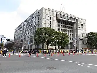 Corredoras passam em frente ao prédio da Prefeitura de Osaka.