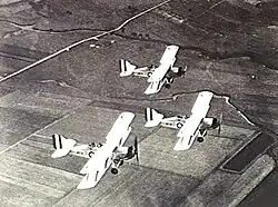 Overhead shot of three military biplanes in flight