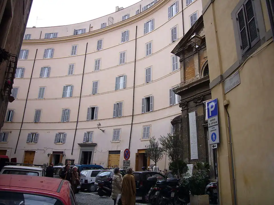 Os edifícios da Piazza di Grotta Pinta seguem a curvatura do antigo Teatro de Pompeu. A igreja de Santa Maria, visível à direita, ocupa um dos corredores de acesso (cavea) do teatro.