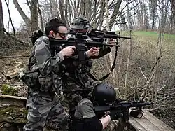 Três membros da equipe de airsoft durante um jogo de campo.