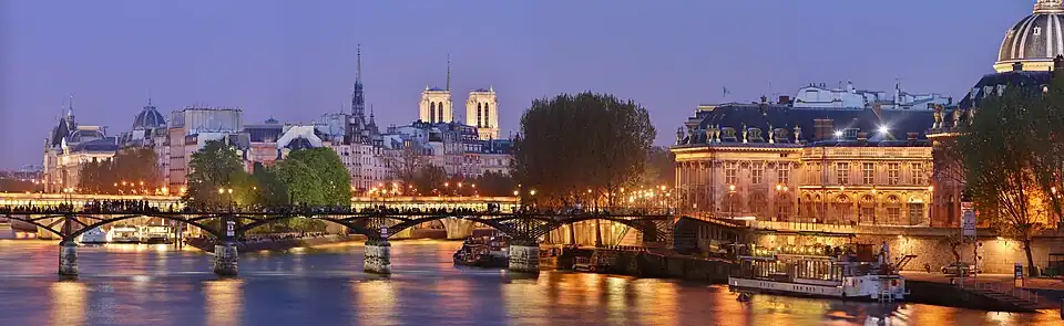 Panorama sobre o Pont des Arts e o Institut de France, à noite.
