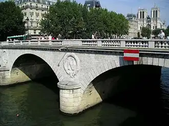 Haussmann reconstruiu a Ponte Saint-Michel que liga a Ilha da Cidade à margem esquerda. Ainda hoje ostenta a letra inicial **N** de Napoleão III.
