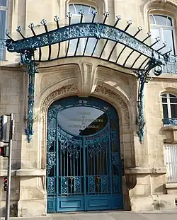 Porta Art Nouveau de metal e vidro em Nancy (França), com uma grande marquise transparente acima