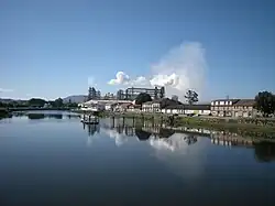 O rio Ulla à sua passagem por Pontecesures; ao fundo: a fábrica de leite condesado da Nestlé