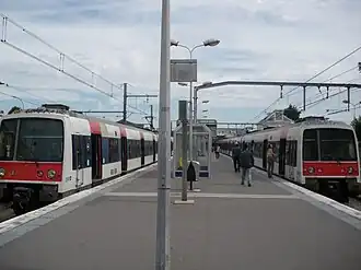 Dois trens MI 79 esperando perto das aldravas da estação.