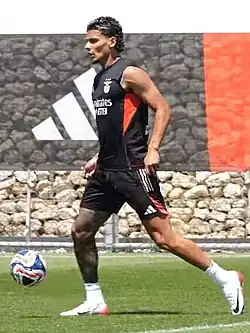 Um homem jogando futebol, com uma bola perto de si.