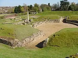 Roman theatre packed-earth entryway and central stage surrounded by grass-covered seating hillocks (ruins)