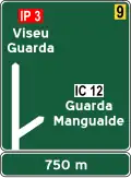 I2d — Pré-aviso gráfico de interseção desnivelada: tem inscritos os destinos referidos a cada uma das direções do esquema gráfico, bem como a identificação das vias que lhes estão associadas, podendo conter sinais verticais