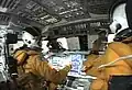 Astronautas da missão STS-107 na cabine do ônibus espacial.