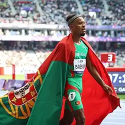 O atleta paralímpico Sandro Baessa com a bandeira de Portugal sobre os ombros