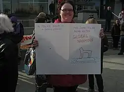 Manifestante segurando um cartaz desenhado a mão