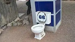 Vaso sanitário e cabina telefônica exposta para efeito de humor no jardim