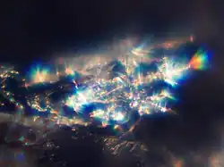 Cristais de neve sob luz solar direta forte agem como pequenos prismas.