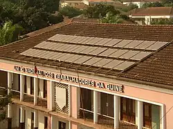 dezenas de painéis solares no telhado de um sobrado de coloração rosa