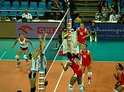 Partida do Campeonato Europeu de Voleibol Feminino de 2009 entre Turquia e França na Hala Stulecia em Wrocław, Polônia. Turquia está de uniforme vermelho e frança branco, é uma partida de vôlei