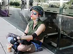 Uma jovem mulher vestida de Tank Girl sentada fumando um cigarro