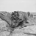 A Churchill tank, carrying a fascine, crosses a ditch using an already deployed fascine, 1943.
