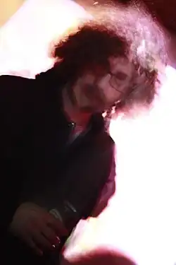 foto desfocada e inclinada de um homem jovem com um microfone na mão direita