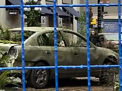 Film set of an actor walking among broken cars