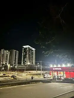 A imagem mostra edifícios de um Bairro da cidade de Uberlândia durante a noite com luzes acesas.