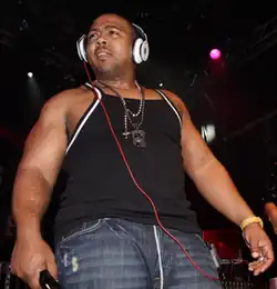 Timbaland usando fones de ouvido e olhando para a direita.