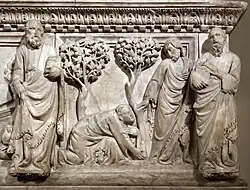 Painel esculpido em baixo e alto-relevo representando duas árvores e quatro homens, um deles ajoelhado
