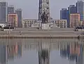 A parte inferior da Torre da Ideologia Juche, com o rio Taedong em primeiro plano e edifícios simétricos em segundo plano.