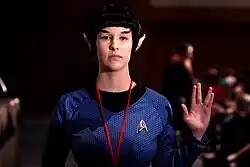 Uma mulher de cosplay de vulcano fazendo a saudação.