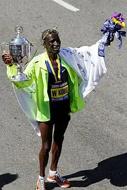 O queniano Wesley Korir ergue o seu troféu de campeão de 2012.