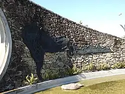 Mapa da América do Sul com o Brasil, e uma representação da Serra do Mar (a Muralha) com o nome da cidade.